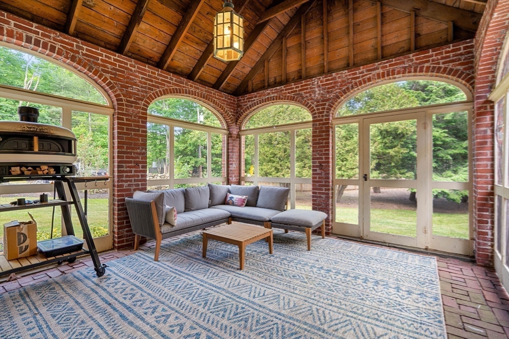161 Spofford Road Boxford, MA 01921 - Photo 25 of 30 a living room with furniture a flat screen tv and a floor to ceiling window