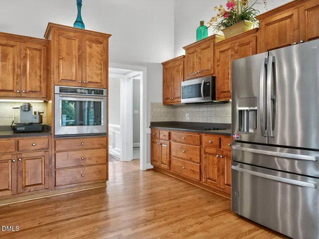 a kitchen with granite countertop wooden cabinets and stainless steel appliances