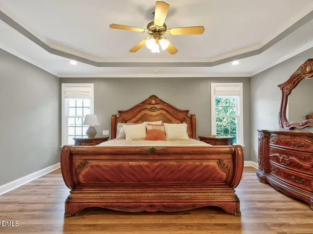 a bedroom with a bed a dresser and flat screen tv