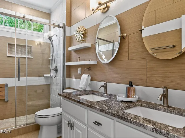 a bathroom with a granite countertop toilet sink and mirror
