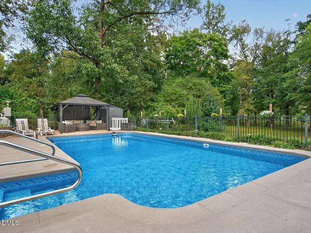 a view of a swimming pool with a patio and a yard