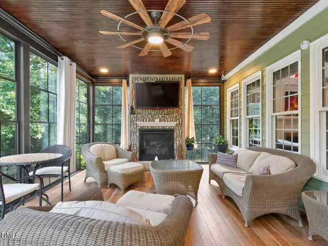 a living room with furniture a fireplace and a large window