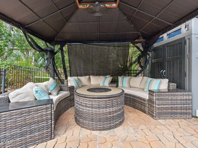 a view of swimming pool with outdoor seating and trees in the background