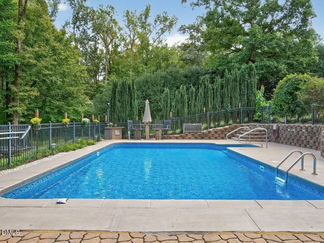 a view of a swimming pool with a patio and a yard