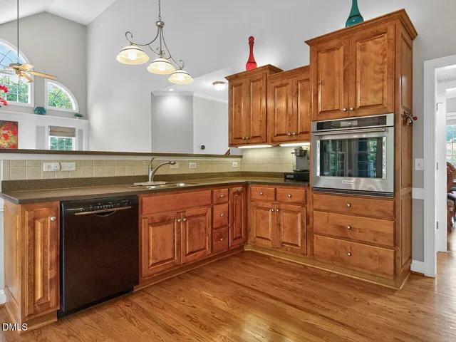 a kitchen with stainless steel appliances granite countertop a stove a sink and a microwave oven with cabinets
