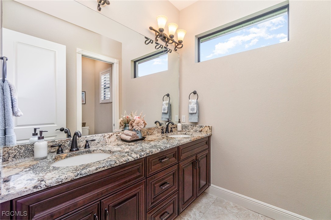 6135 Calusa Rdg Trail Bokeelia, FL 33922 - Photo 27 of 46 a bathroom with a granite countertop sink and a mirror