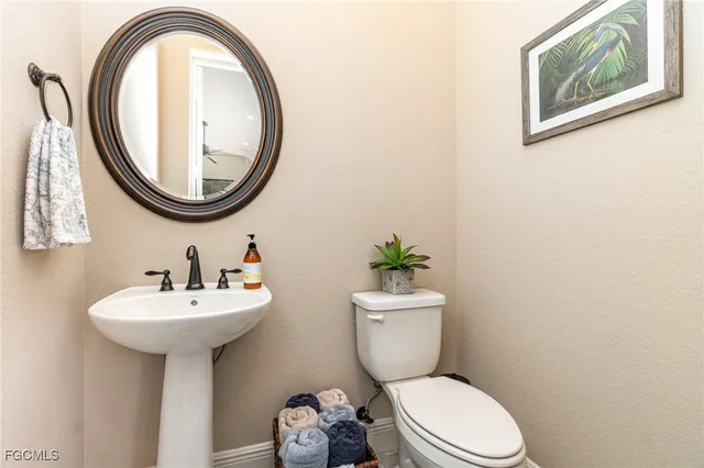 a bathroom with a toilet a sink and a mirror