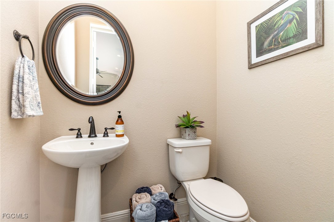 6135 Calusa Rdg Trail Bokeelia, FL 33922 - Photo 31 of 46 a bathroom with a toilet a sink and a mirror