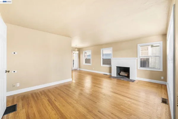 a view of empty room with wooden floor and fireplace