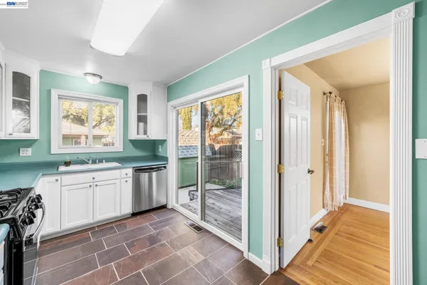 a kitchen with granite countertop a stove a sink and a refrigerator