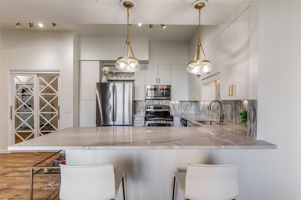 3225 Turtle Creek, Unit 719 Dallas, TX 75219 - Photo 1 of 24 an open kitchen with refrigerator and mirror