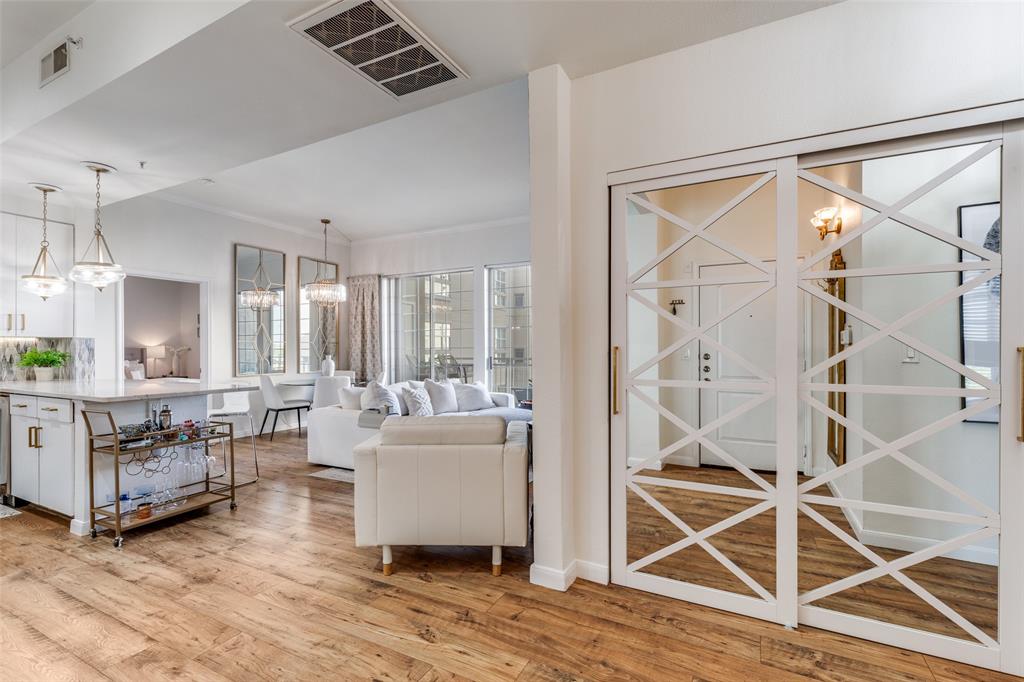 3225 Turtle Creek, Unit 719 Dallas, TX 75219 - Photo 15 of 24 a living room with furniture a wooden floor and a chandelier