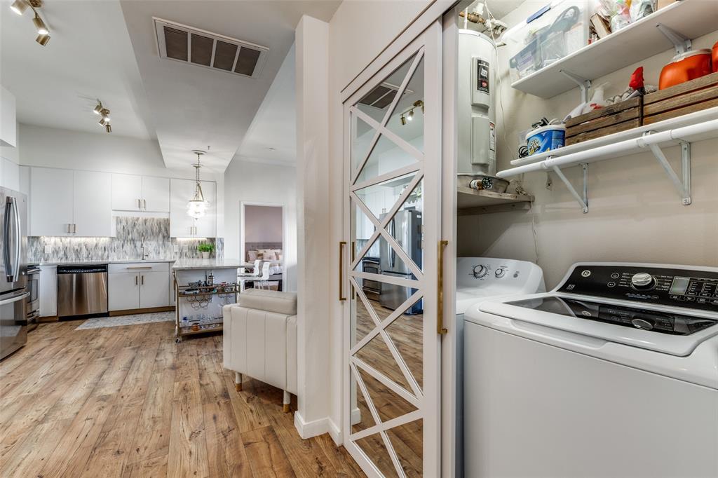 3225 Turtle Creek, Unit 719 Dallas, TX 75219 - Photo 16 of 24 a kitchen that has a lot of cabinets stainless steel appliances and wooden floor