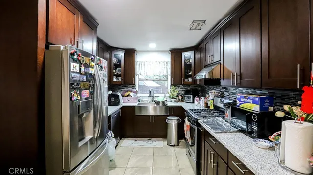a kitchen with stainless steel appliances granite countertop a refrigerator and a stove