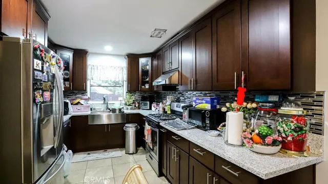 a kitchen with lots of clutter and stainless steel appliances