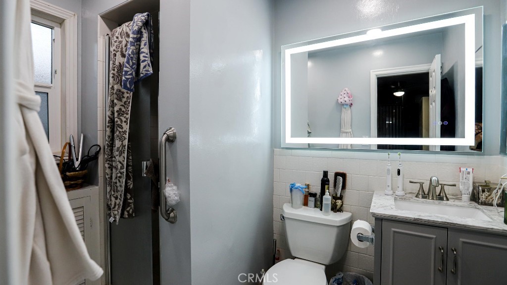 11821 Easy Way Garden Grove, CA 92840 - Photo 20 of 48 a bathroom with a granite countertop sink toilet and mirror