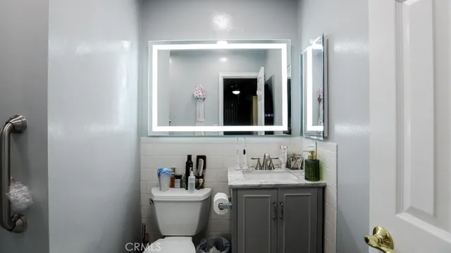 a bathroom with a granite countertop sink toilet and mirror