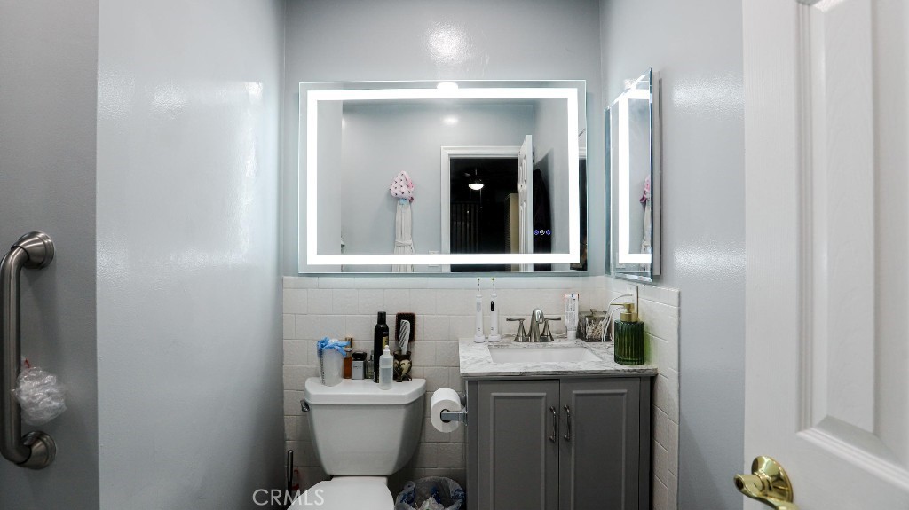 11821 Easy Way Garden Grove, CA 92840 - Photo 21 of 48 a bathroom with a granite countertop sink toilet and mirror