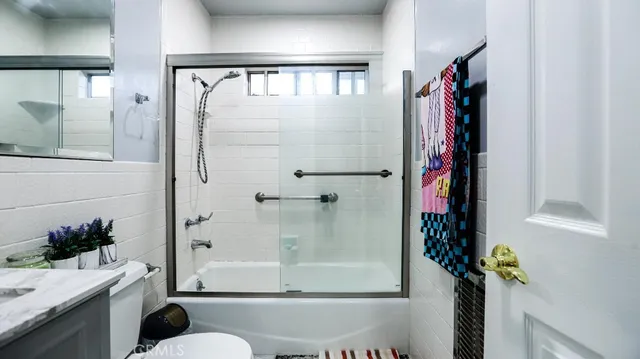 a bathroom with a shower curtain and a potted plant
