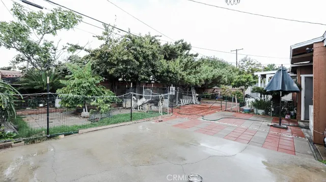 a view of backyard with wheel chair potted plants and large tree