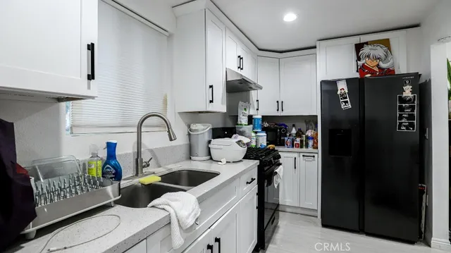 a kitchen with stainless steel appliances granite countertop a refrigerator and a sink