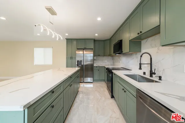 a large kitchen with stainless steel appliances lots of counter top space