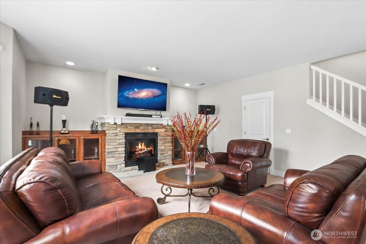901 Jericho Place Northeast Renton, WA 98059 - Photo 15 of 38 a living room with furniture a fireplace a projector and a flat screen tv