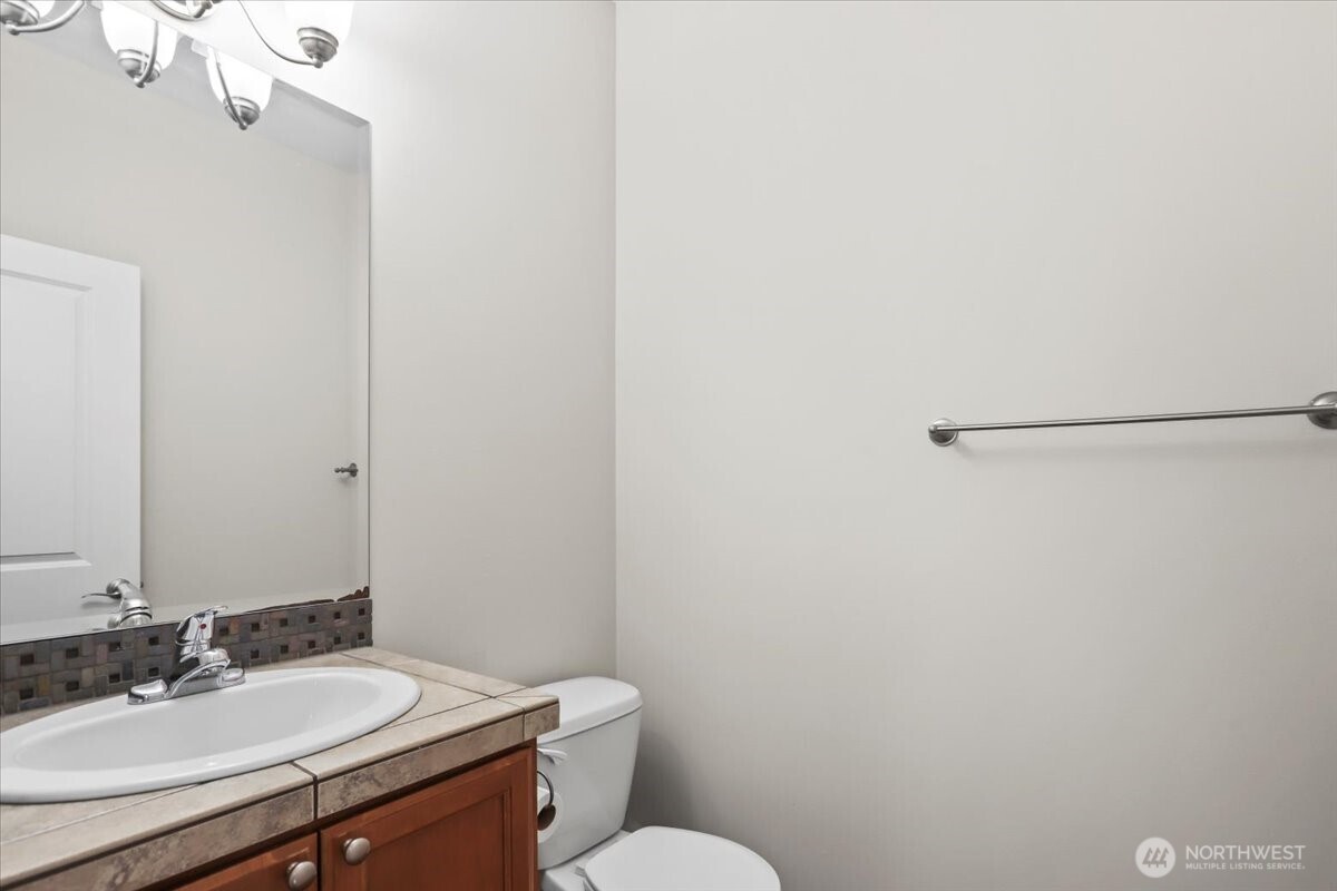 901 Jericho Place Northeast Renton, WA 98059 - Photo 8 of 38 a bathroom with a granite countertop sink mirror vanity and toilet