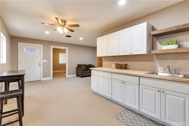a kitchen with granite countertop a sink cabinets stainless steel appliances and a window