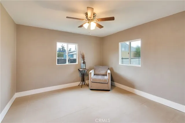 an empty room with windows and ceiling fan