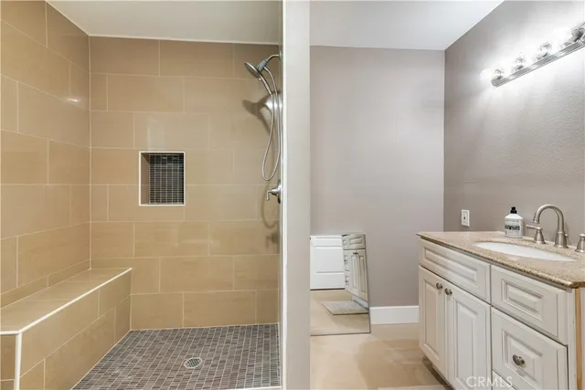a bathroom with a granite countertop sink a toilet and shower