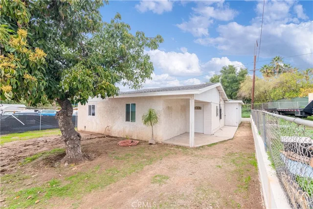 a view of a house with backyard and a tree