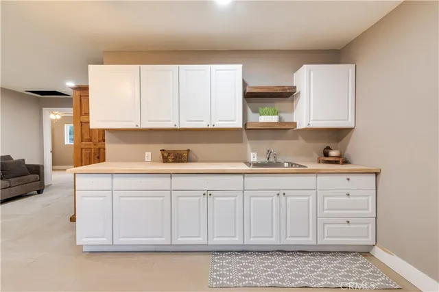 a kitchen with granite countertop white cabinets and sink