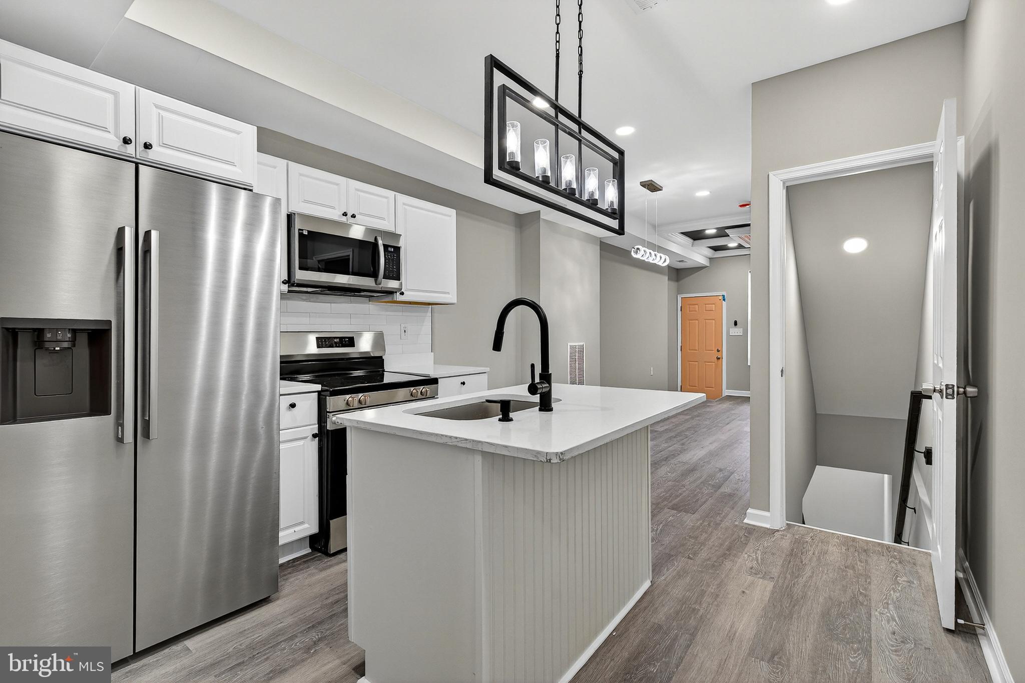 a kitchen with stainless steel appliances a sink and refrigerator