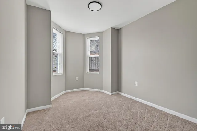 a view of an empty room with closet and a window