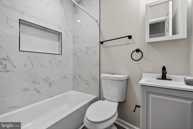 a bathroom with a toilet a sink and mirror