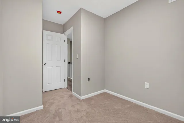 an empty room with an entryway and closet