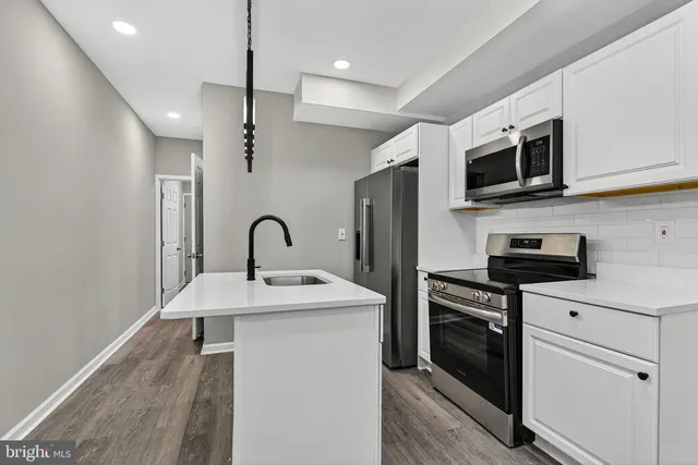 a kitchen with stainless steel appliances granite countertop a stove a sink and a microwave