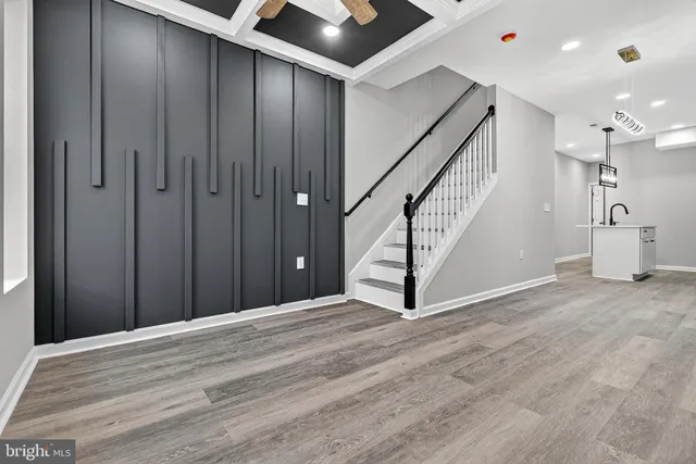 a view of an empty room with stairs and a ceiling fan