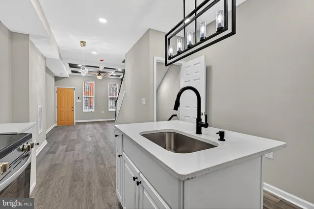 a kitchen with kitchen island a sink and a stove top oven