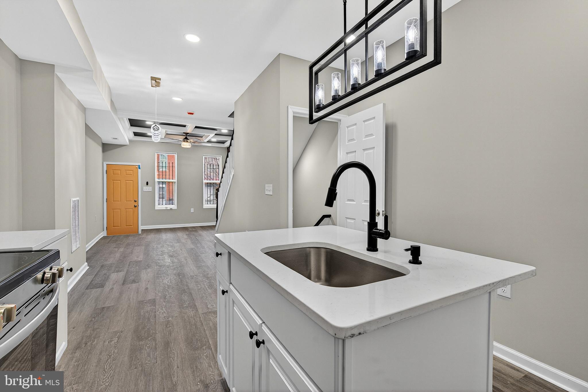 328 South Payson Street Baltimore, MD 21223 - Photo 7 of 27 a kitchen with kitchen island a sink and a stove top oven