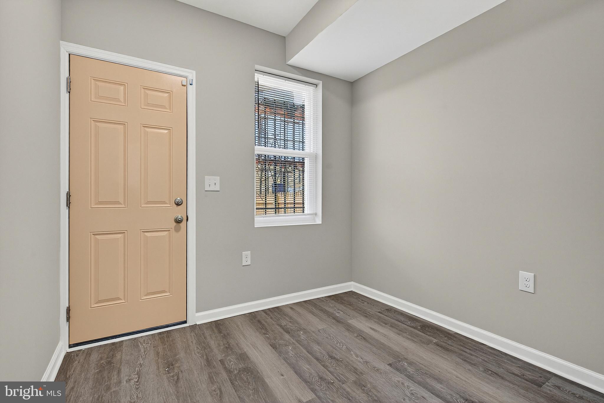 328 South Payson Street Baltimore, MD 21223 - Photo 10 of 27 an empty room with wooden floor and windows