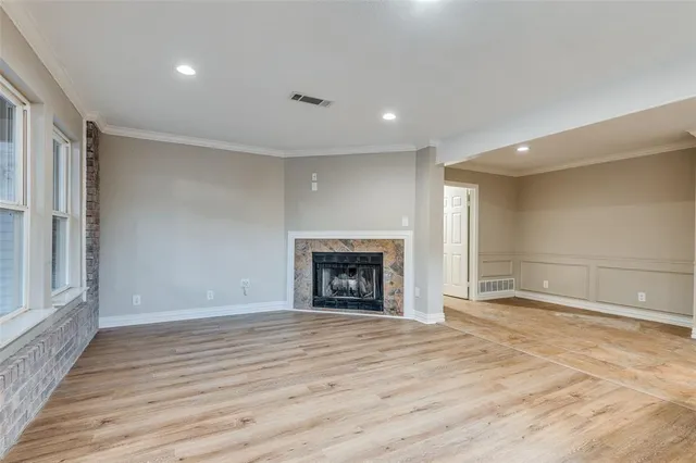 a view of an empty room with a fireplace and a window