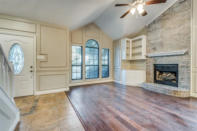 wooden floor fireplace and windows in an empty room