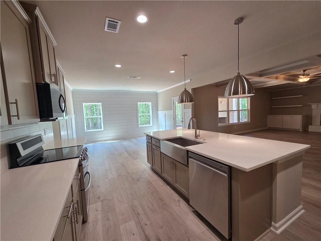 293 Meadows Drive Bethlehem, GA 30620 - Photo 16 of 34 a kitchen with stainless steel appliances granite countertop a sink a stove and a wooden floor