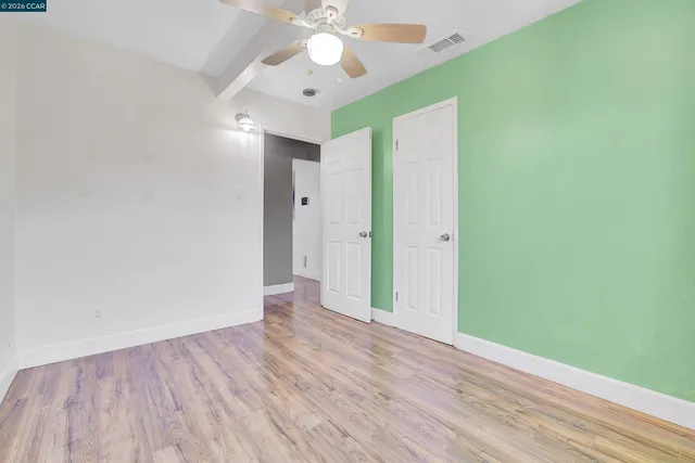 a view of an empty room with wooden floor