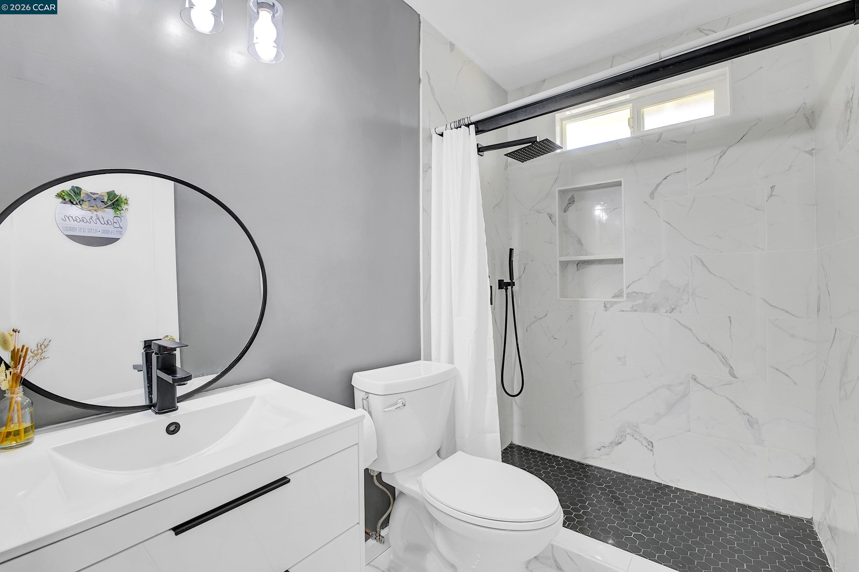 149 Shore Road Bay Point, CA 94565 - Photo 14 of 30 a bathroom with a toilet a sink and a mirror