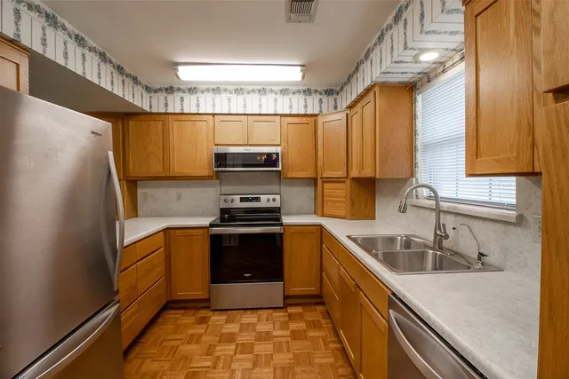 a kitchen with stainless steel appliances granite countertop a sink stove and refrigerator