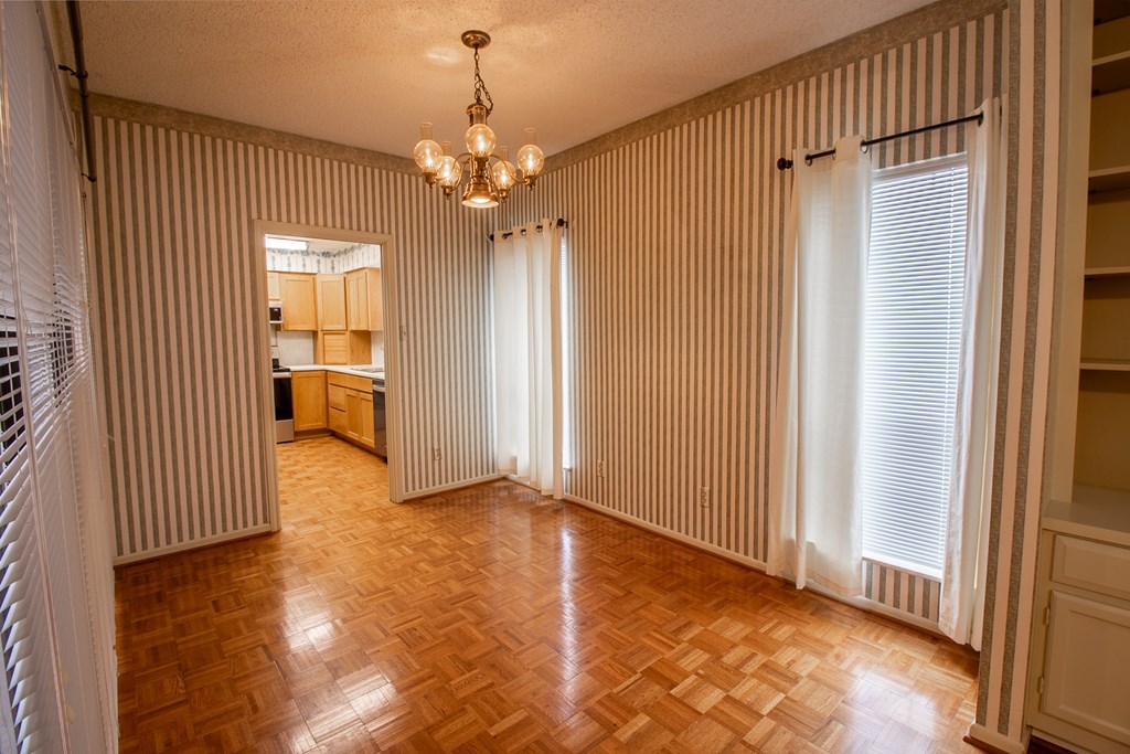 1127 Lois Street Kerrville, TX 78028 - Photo 7 of 23 an empty room with wooden floor chandelier and windows