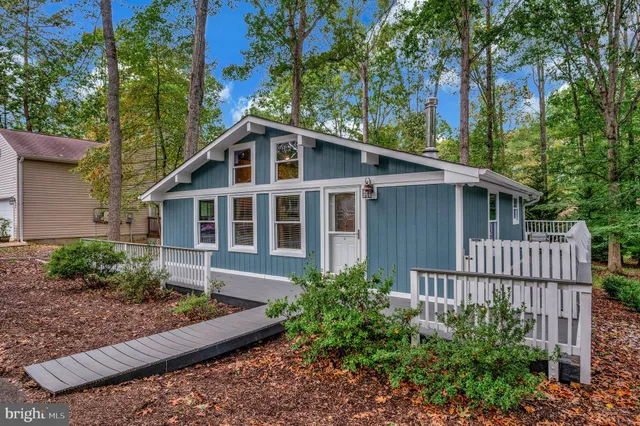 a view of wooden house with a deck